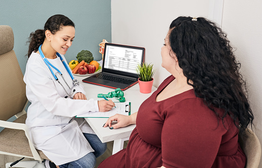 Obesity, unhealthy weight. Nutritionist calculating body mass index of fat woman for obesity treatment