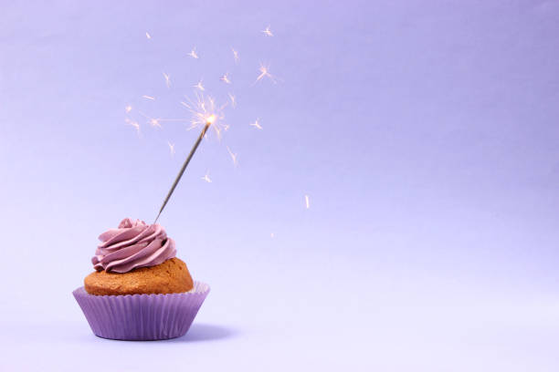 istock Delicious cupcake with a candle on a colored background with space for text. 1314346863