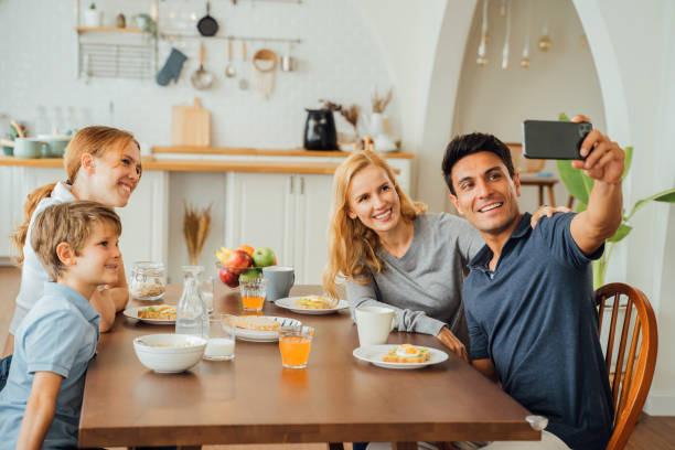 istock Family group taking a photo with smart phone while eating breakfast 1314347045