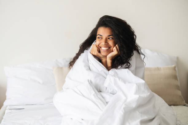 istock Young mixed-race woman covered in a soft blanket 1314348756