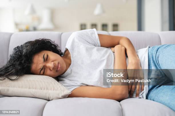 African American Woman Suffering From Cramps Stock Photo - Download Image Now - Irritable Bowel Syndrome, Stomachache, Illness