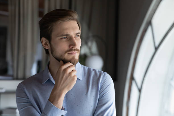 istock Thoughtful young man leader looking at window visualizing business opportunities 1314352195