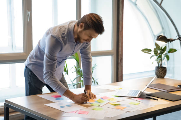 istock Thoughtful male employee correcting mistakes in marketing plan by hand 1314352283