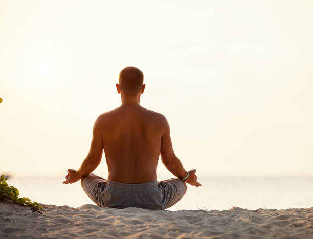 istock Calm man meditating on beach at sunset 1314353416