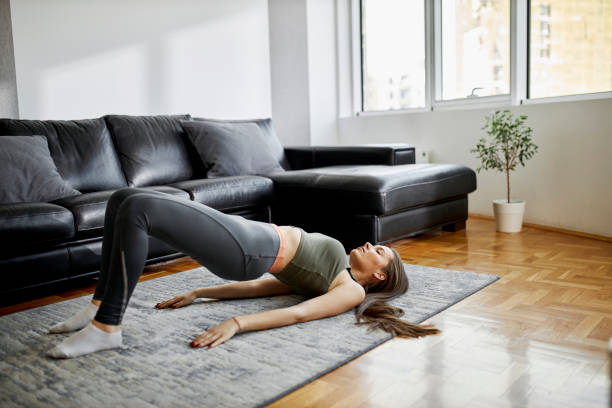 istock Young sporty woman practicing yoga, doing dvi pada pithasana exercise, Glute Bridge pose, working out, wearing sportswear, grey pants and top, indoor 1314354037