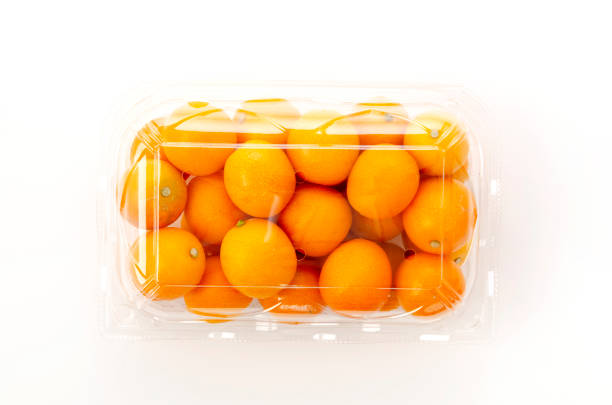 istock Fresh Kumquat fruit in a plastic fruit container on white background 1314354887