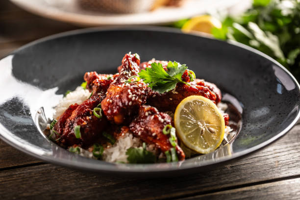 istock Marinated glazed chicken sprinkled with seesame served over white rice with coriander and a slice of lemon. 1314355391