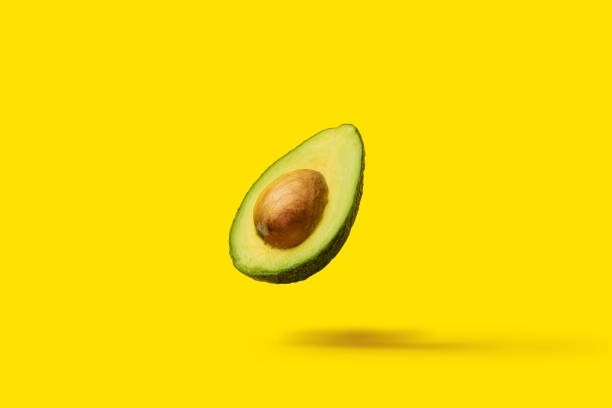 istock avocado with a bone fly in the air on a yellow background. Top view, flat lay 1314356161