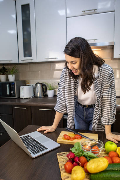 istock woman cooking checking recipe at laptop 1314356744