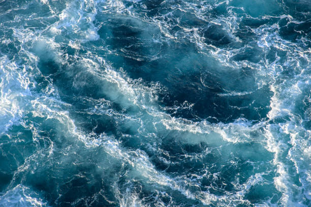 istock Stormy ocean waves backlit by the light of the setting sun. 1314357056
