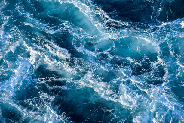 istock Stormy ocean waves backlit by the light of the setting sun. 1314357078