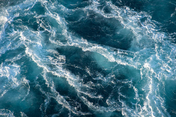 istock Stormy ocean waves backlit by the light of the setting sun. 1314357088