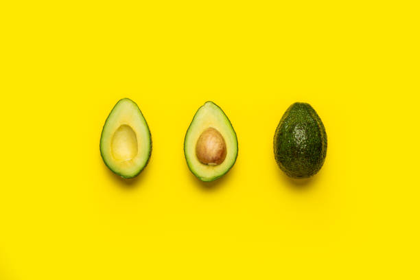 istock cut with a bone and a whole avocado on a bright yellow background. Top view, flat lay 1314357114