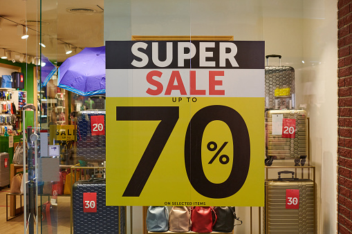 Seasonal super sale 70% off, holiday discount in shopping mall. New Year's sale time at european shopping center. Christmas promotions in accessories store.