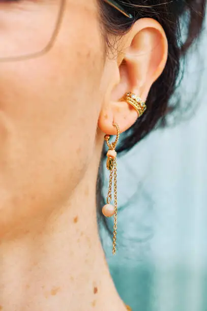 Photo of Close up image of female ear wearing modern earring