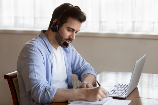 istock Young man in earphones study distant on laptop 1314362429