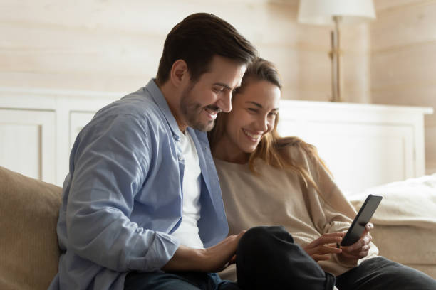istock Smiling couple use cellphone talk on video call 1314362446