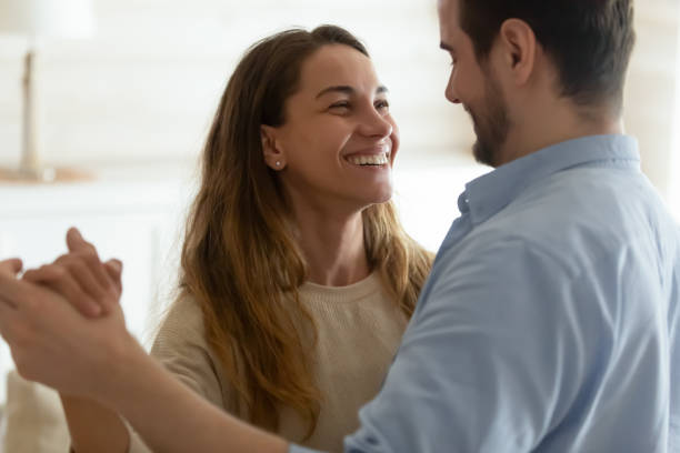 casal jovem feliz dança em casa celebrando - waltzing - fotografias e filmes do acervo