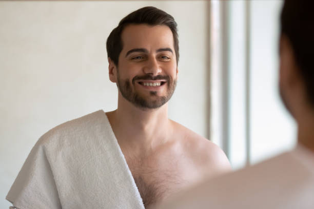 istock Smiling millennial man look in mirror in bath at home 1314362483