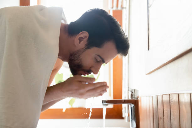 istock Young man clean face in home bathroom 1314362486