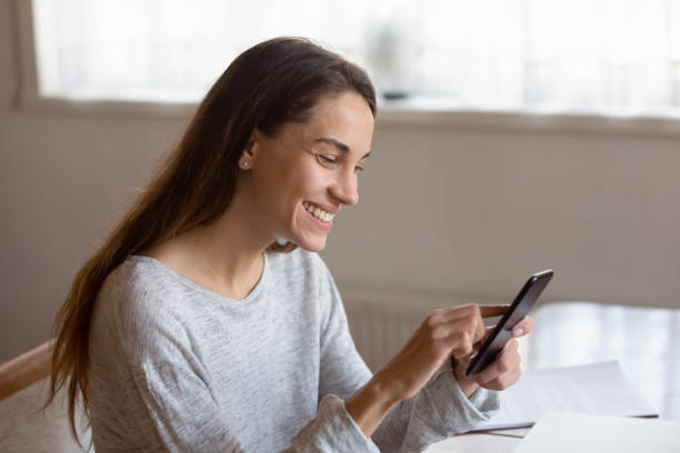istock Smiling young woman use cellphone browsing internet 1314362494