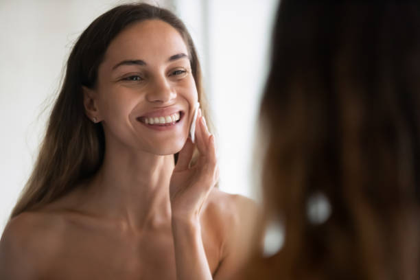 istock Smiling Latin woman look in bath mirror clean face 1314362500