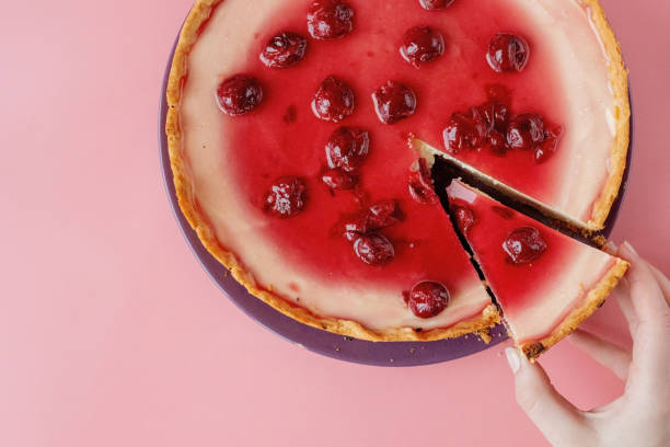 istock Slice of plain cheesecake with cranberry sauce on white plate decorated with mint leaf. Closeup view 1314362650