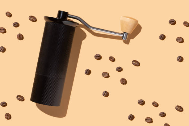 istock Coffee bean grinding process concept, beans, manual coffee grinder on a beige background, hard trend light 1314366518