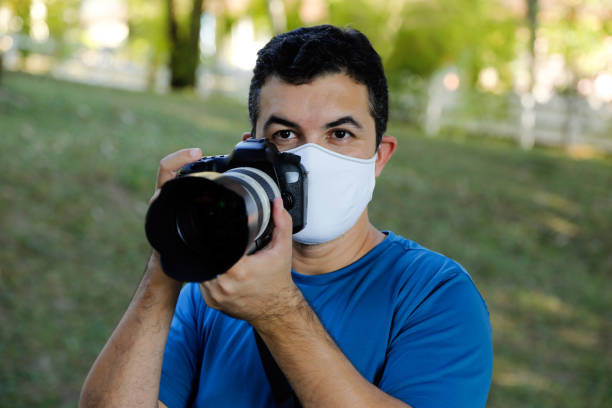 white man wearing photo camera and respiratory mask during work