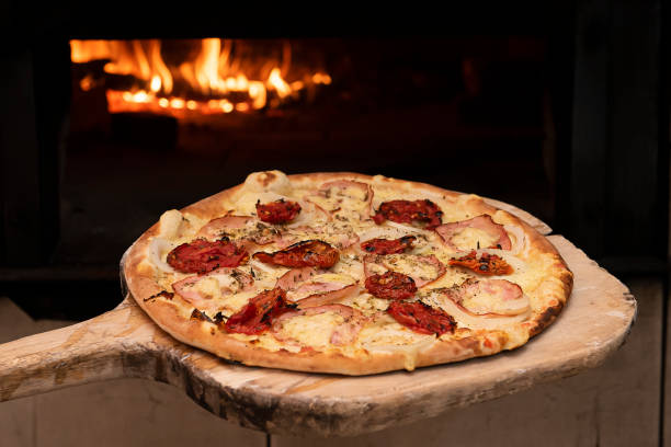 istock Brazilian style pizza entering the wood oven. Selective focus 1314367736