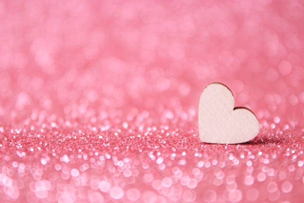 Pink wicker heart on a white painted wooden background. Space for copy.