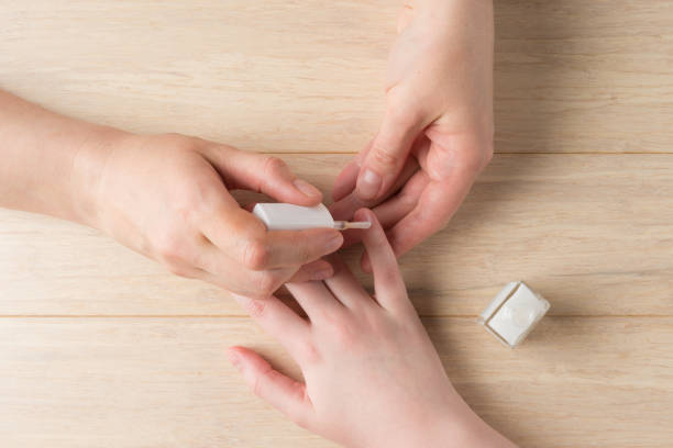istock Female hands making manicure at home. Applying transparent nail polish 1314368909