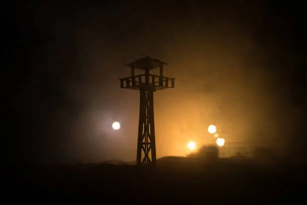 Creative artwork decoration. War concept. Silhouette of army watchtower at night. Selective focus