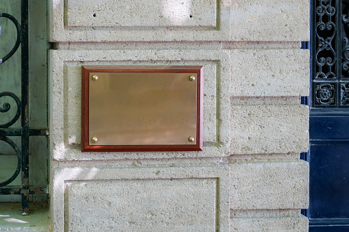 empty copper blank plate on the entrance signboard on textured wall mockup for notary doctor office