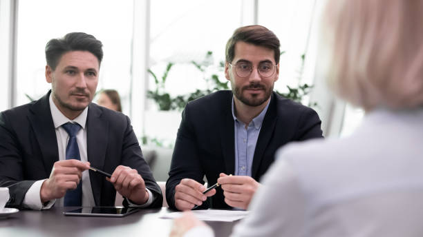istock Confident businessmen talk with client at business meeting 1314375793