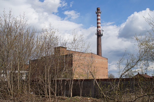 the chimney and the building of the old disused sugar factory against the sky in Plock