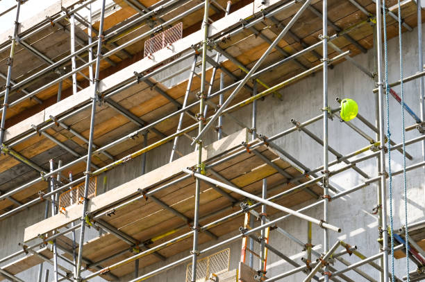 Safety helmet hanging from scaffolding Single safety helmet hanging on the end of a scaffolding pole on a construction site. No people. scaffolding stock pictures, royalty-free photos & images