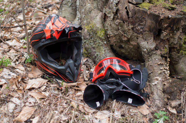 istock Black anf red helmet, goggles and motorcycle gloves in forest 1314380106