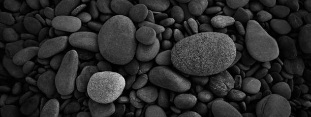 istock Dark black abstract smooth round pebbles sea texture background 1314381677
