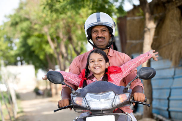 Happy father with carefree daughter riding on motorcycle