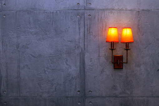 lamp (sconce) on a rough, gray concrete wall. copy space