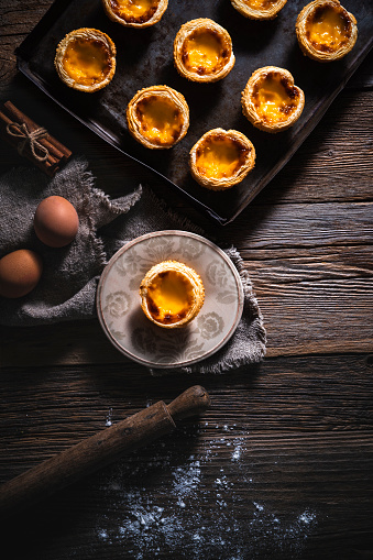 Belem cakes or Pasteis de Belem, Portuguese traditional recipe pastel de Nata Custard Tarts with ingredients on rustic wooden table