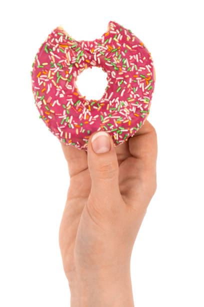 istock Donut close-up in hand on a white background. Bitten donut isolated on white background. 1314384266