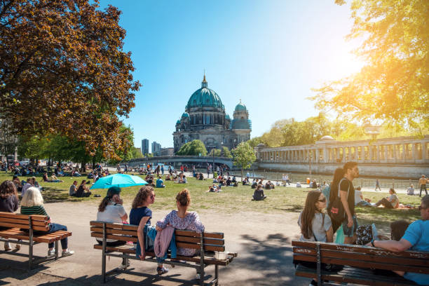 People in public park on a sunny day near Museum Island and Berlin Cathedral stock photo
