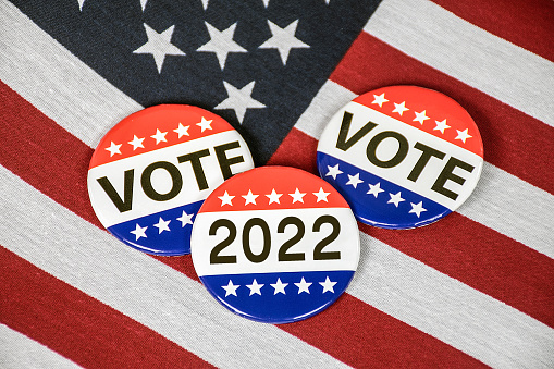 Election campaign vote buttons on American flag for 2022