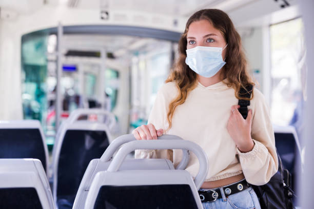 istock Young lady in face mask riding on tram to her work 1314389353