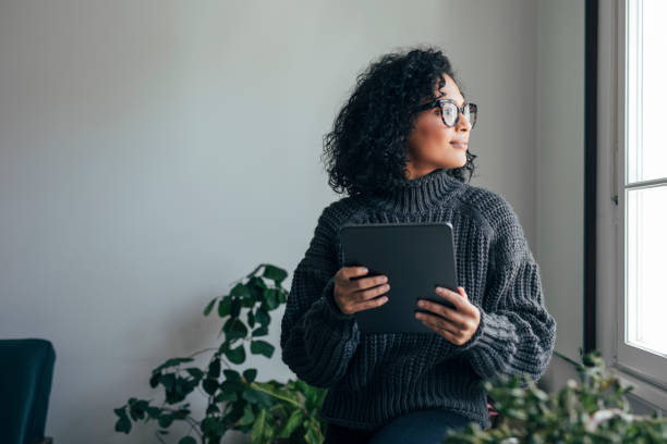 istock Working from Home: a Young Woman Using a Digital Tablet, Looking Away (Horizontal) 1314391809