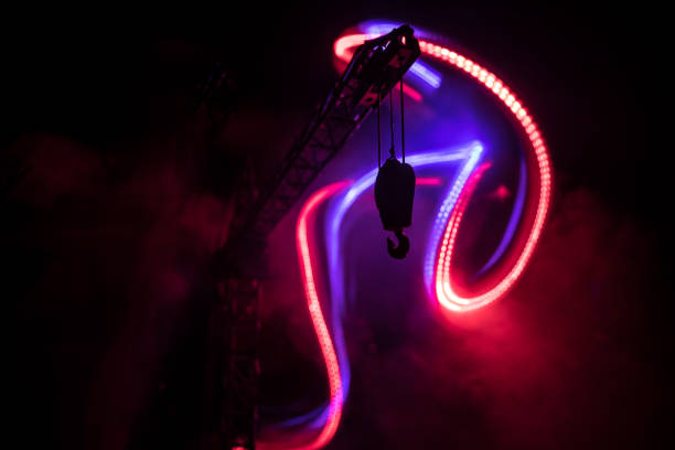 istock Abstract Industrial background with construction crane silhouette over amazing night sky with fog and backlight. Tower crane against the foggy sky at night. 1314392368