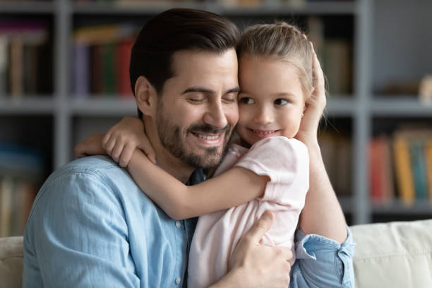 istock Affectionate young man cuddling cute small preschool kid daughter. 1314393193