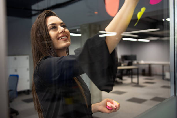 istock Businesswoman sticking notes on the windows, business planning 1314393229